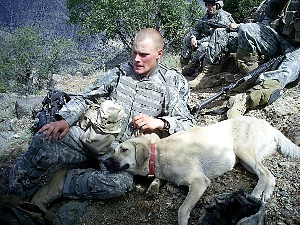 Sheldon resting with a dog during military service